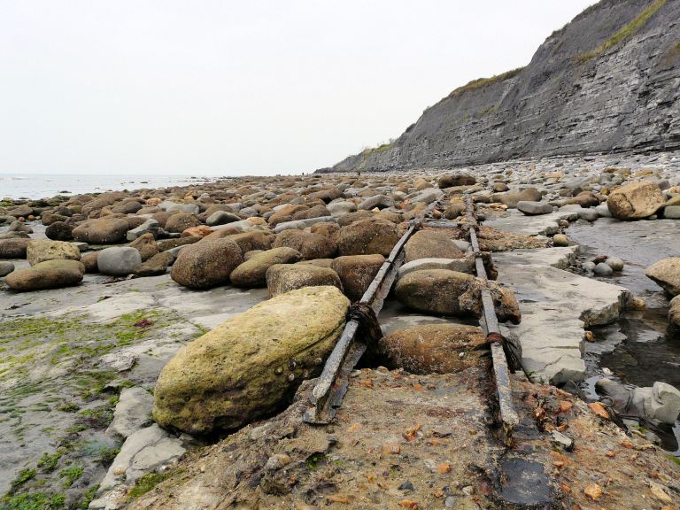 Looking westwards at old Victorian rail track and concrete seatings on Monmouth Beach, Lyme Regis, Dorset - part of the Jurassic Coast