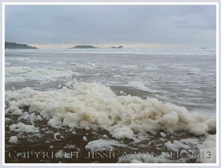 Wet, wild & windy at Rhossili (2) - Piles of sea foam on the sand at Rhossili bay, Gower, South Wales, 14th November 2009, with Worms Head in the background.