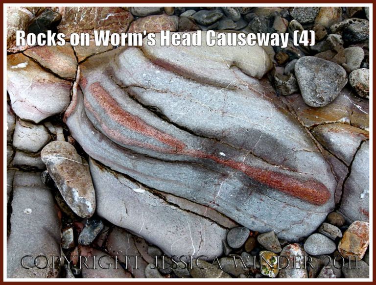 Rock on Worm's Head Causeway: Water-worn Carboniferous limestone grey rock strata with cracks and fissures and red rock vein on the Worm's Head Causeway, Rhossili, Gower, South Wales, UK (4)