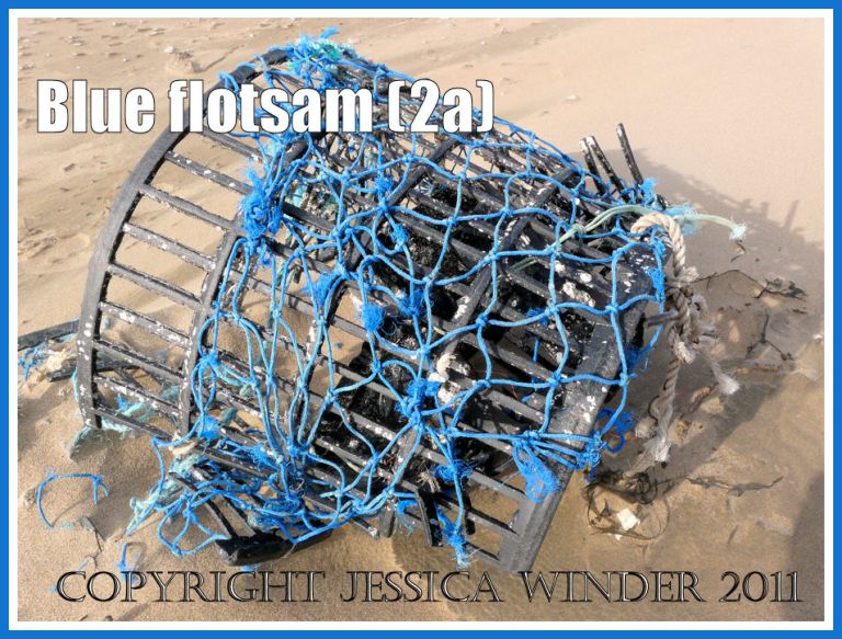 P1180149aBlog2a An old fishing pot with blue netting washed ashore as flotsam on the sandy beach at Rhossili Bay, Gower, South Wales, UK (2a) Rhossili flotsam: An old fishing pot with blue netting washed ashore as flotsam on the sandy beach at Rhossili Bay, Gower, South Wales, UK (2a)