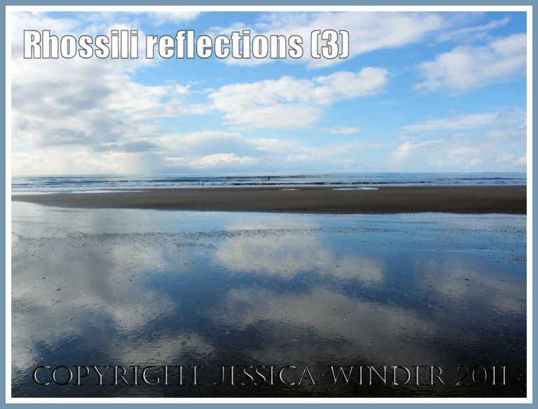 Clouds and reflections: Reflection of fluffy white clouds and blue sky in the wet sand on the shore at Rhossili Bay, Gower, West Glamorgan, UK (3)