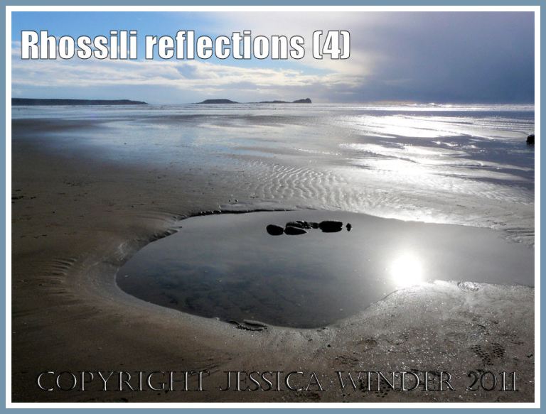 Beach reflections: The sun reflected by pools, wet sand, and the sea at Rhossili Bay, Gower, West Glamorgan, UK - with Worms Head on the horizon (4)