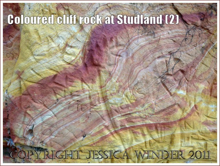 Coloured rock pattern: Red and yellow strata in the cliffs at Studland Bay, Dorset, UK, on the Jurassic Coast - with carved graffiti (2)