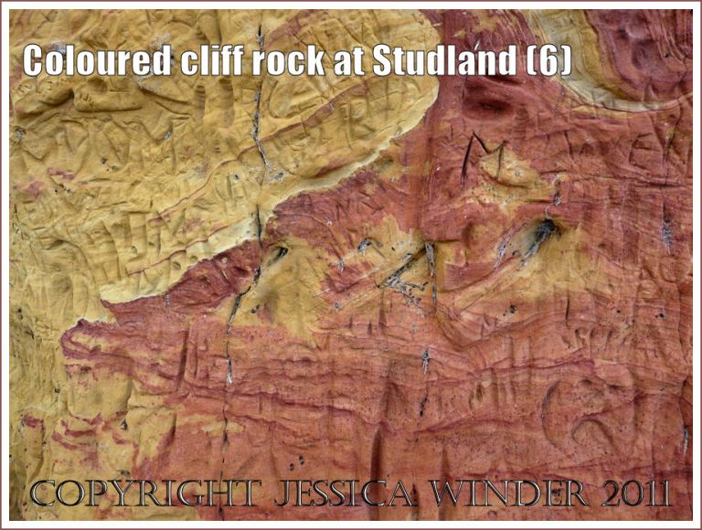 Rock colour, pattern, and texture: Red and yellow rock strata in the cliffs at Studland Bay, Dorset, UK, on the Jurassic Coast - with carved graffiti (6)