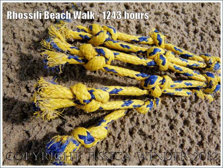 Rhossili Beach Walk - 1243 hours. Yellow and blue fishing net embedded in wet sand on Rhossili Beach, Gower, South Wales, 22nd August 2012.
