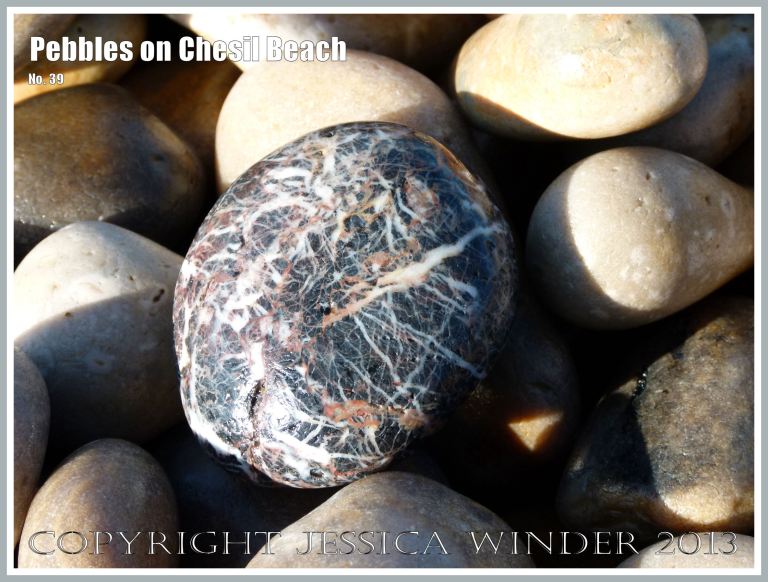 Dark grey glassy pebble with red and white lines