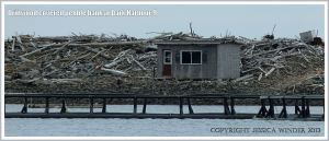 Driftwood timbers and fishermen's hut on a pebble bank