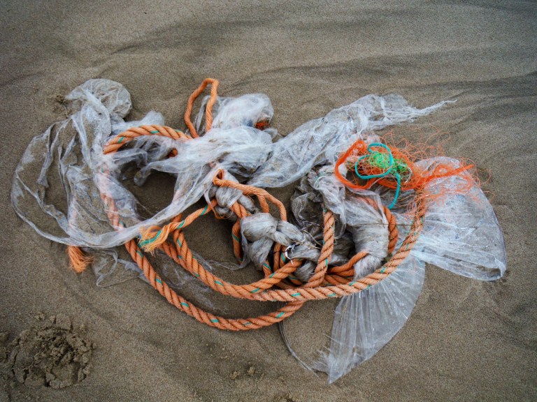 Orange rope and polythene flotsam on the beach