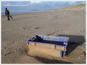 Blue plastic flotsam crate on the beach
