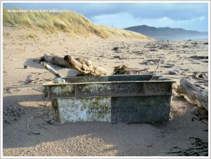 Black and white fishing crate flotsam on beach