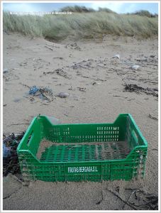 Green plastic crate rubbish on beach
