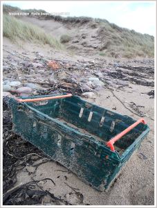 Green plastic crate rubbish on beach