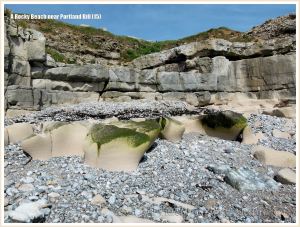 Looking upshore over limestone outcropping amongst pebbles to quarried cliff face on the beach