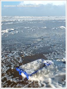Blue plastic crate washed up in sea foam