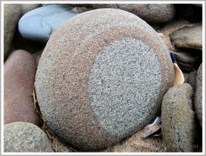 Pebble with a natural pattern photographed where it was found on the beach