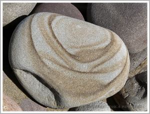 Pebble with a natural pattern photographed where it was found on the beach