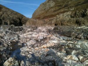 Bare rocks revealed where storms washed away the sand at Mewslade Bay