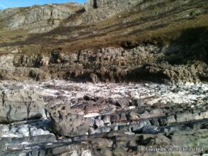 Bare rocks revealed where storms washed away the sand at Mewslade Bay