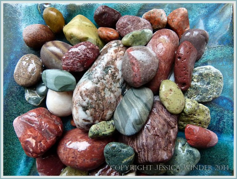 Red, green and patterned pebbles in a dish