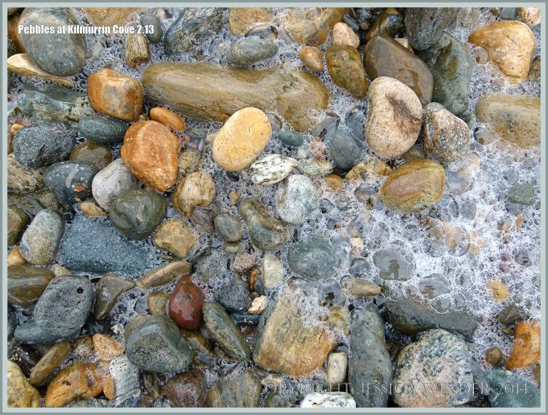 Wet pebbles with sea foam bubbles at Kilmurrin Cove