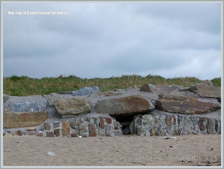 Rip-rap boulders at the top of a sandy beach