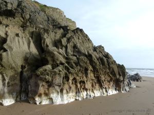 Band of white calcite exposed at the base of the cliffs in Mewslade Bay.