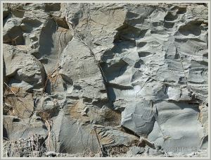 Natural pattern of breaks and fractures in the vertical cliff face of blue-grey Eype Clay Member