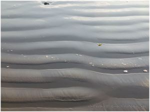 Ripples in wet sand at high tide on Rhossili Beach