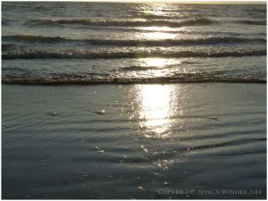 Sun reflections as high tide approaches tide at Rhossili Beach