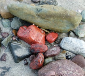 Pebbles on the beach with bright red jasper