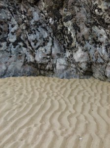 Low tide sand ripple beach pattern at the base of limestone cliffs