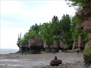 Sea stacks and red cliffs with vertical fissures and horizontal undercutting at Hopewell Rocks in New Brunswick.