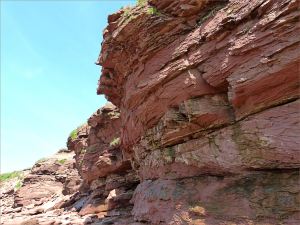 Cliff face with layers of red Triassic rocks at Waterside in New Brunswick.
