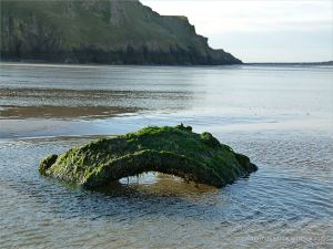 Rusty remains thought to be an old empty WWII mine on Rhossili beach