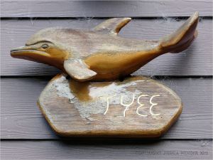 Wood whale carving on house at Yachats, Oregon.