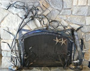 Metal fireguard adorned with sea stars and bull kelp at Overleaf Lodge, Yachats, Oregon