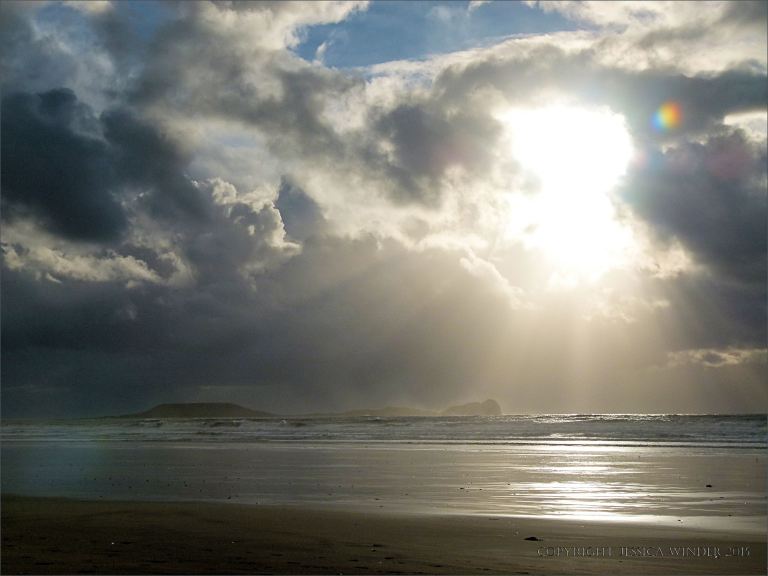 Sun breaking through storm clouds over Worms Head at Rhossili on Christmas Day 2013