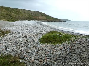 View across the water's edge at Pwll Du Bay
