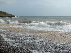 Pebbles on the water's edge at Pwll Du Bay