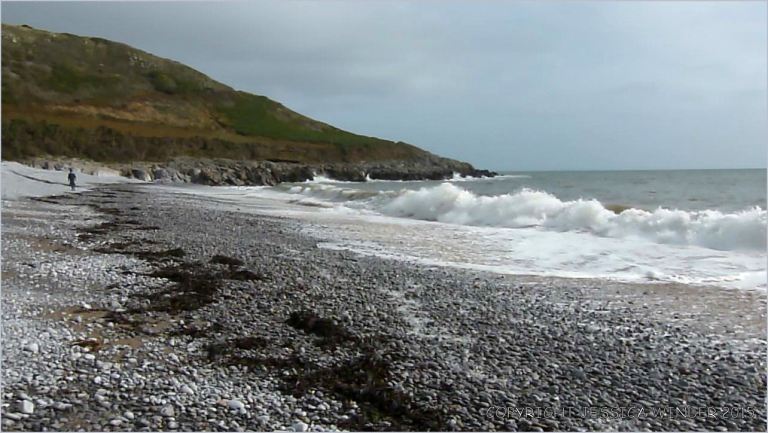 View looking east across the water's edge at Pwll Du Bay