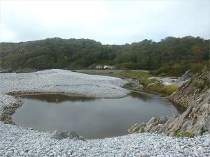 Water dammed behind the shingle banks at Pwll Du Bay