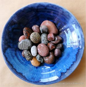 Colourful pebbles in a blue bowl