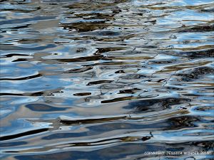 Natural water reflection patterns and textures in the rippled surface of a fountain bowl