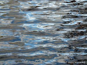 Natural water reflection patterns and textures in the rippled surface of a fountain bowl