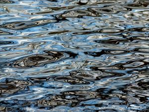 Natural water reflection patterns and textures in the rippled surface of a fountain bowl