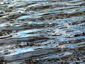 Natural water reflection patterns and textures in the rippled surface of a fountain bowl