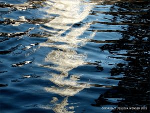 Natural water reflection patterns and textures in the rippled surface of a fountain bowl
