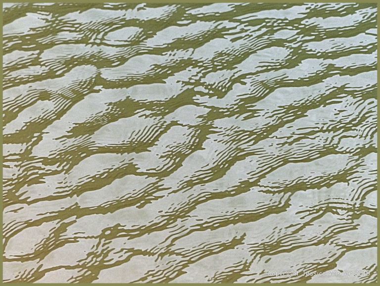Close-up photograph of reflected light on rippled water