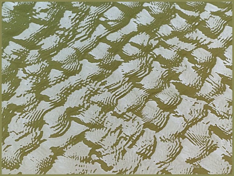 Close-up photograph of reflected light on rippled water