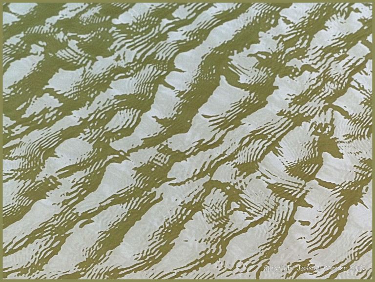 Close-up photograph of reflected light on rippled water